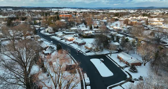 Residential American town in winter snow. Aerial of rancher and single family homes in USA. Flight a