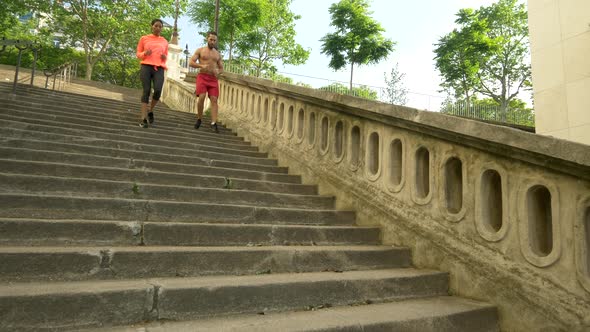 A couple running on stairs in a city as a workout