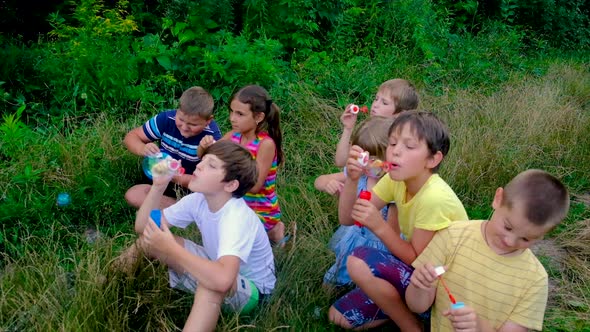 Children Blow Bubbles on the Street