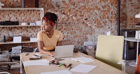 Slow motion shot of design student sitting at table looking sideways