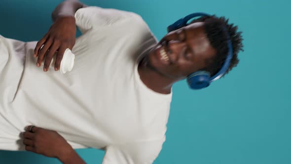 Casual Person Wearing Headphones and Dancing to Song