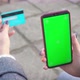 Smartphone and credit debit card in hands of girl smartphone green screen for chroma key on street - VideoHive Item for Sale