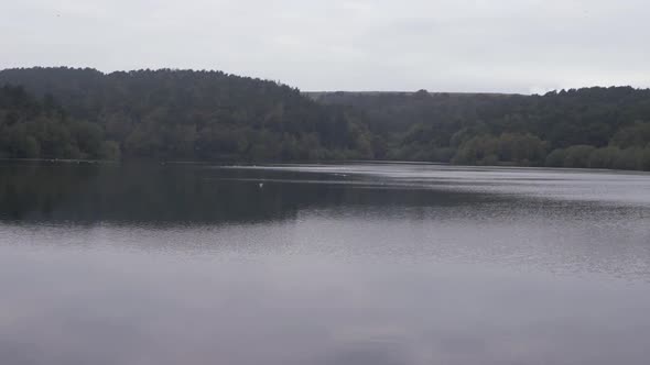 Reservoir in Yorkshire expanse of water with trees wide panning shot