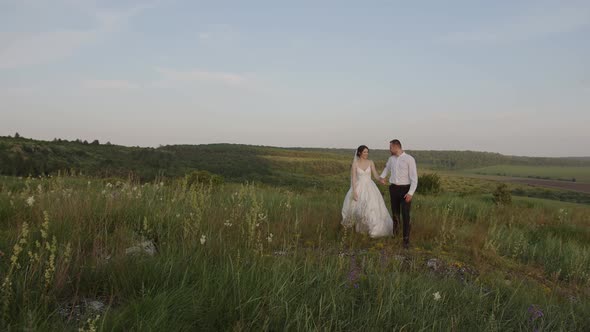 Happy Couple Walks and Hold Their Hands Together