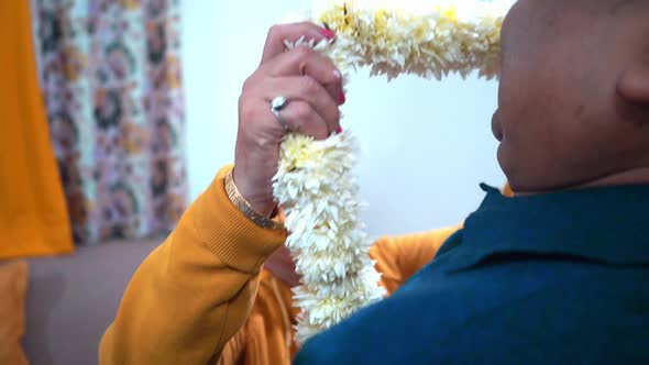 Happy Indian Wife Putting On A White Floral Garland To Her Husband At Home In Agra India Medium Shot