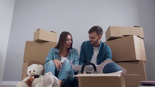 Happy Man and Woman in Stylish Clothes Sitting on the Parquet