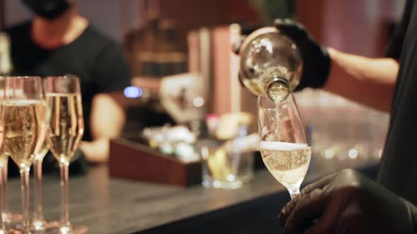 Waiter is Pouring Champagne in the Glass Closeup