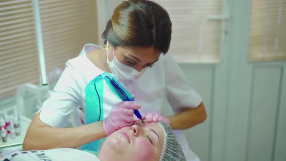 Cosmetologist Applying Permanent Make Up on Eyebrows