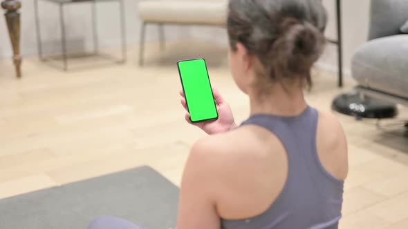 Indian Woman Using Smartphone with Chroma Screen on Yoga Mat