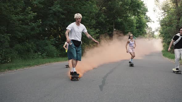 Young Progressive Skaters Ride in the Park with a Smoke Bomb Attached to the Board Do Flips and