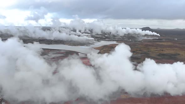 Aerial shot flying through the steam of a geothermal power station.