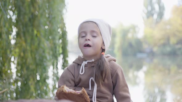 Little Girl Eat Bun Outdoors Caucasian Female Kid Have Fun on Picnic Bite French Puff with Berry