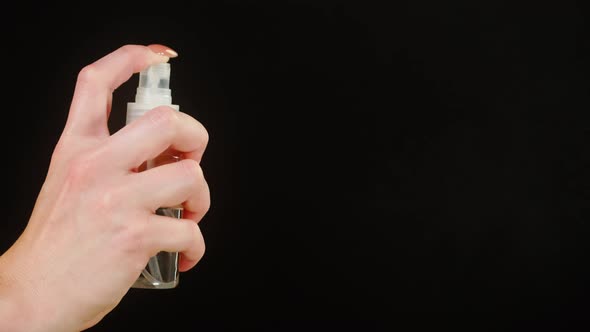 Female Hands Pushing Dispenser with Antiseptic on Black Background