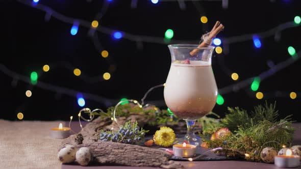 Season Eggnog, Handsome Cocktail Glass with Traditional Egg Drink on Decorated with Christmas Tree