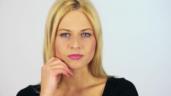 A Young Attractive Woman Nods at the Camera with a Smile - Face Closeup - White Screen Studio