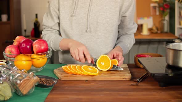 Woman Cutting Oranges for Mulled Wine