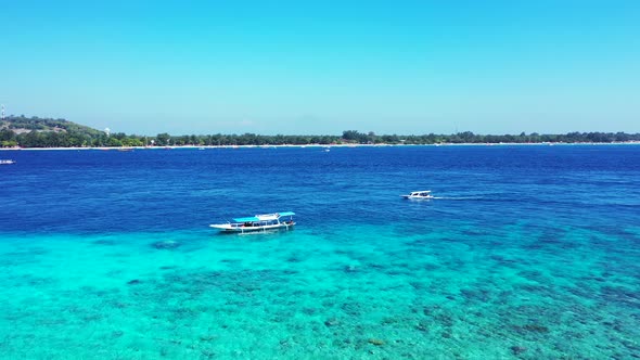 Beautiful above island view of a paradise sunny white sand beach and blue sea background in vibrant 