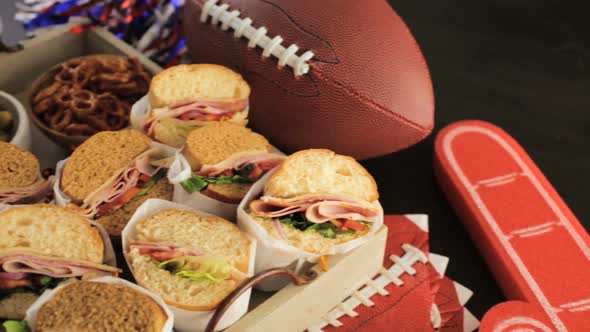 Game day football party table with  sub sandwich and snacks.