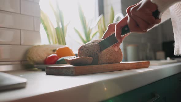 African pregnant woman cuts bread