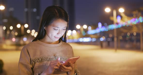 Asian Woman use of smart phone in city at night
