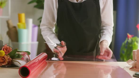 Young Florist Cutting Wrapping Paper for Bouquet at Workplace