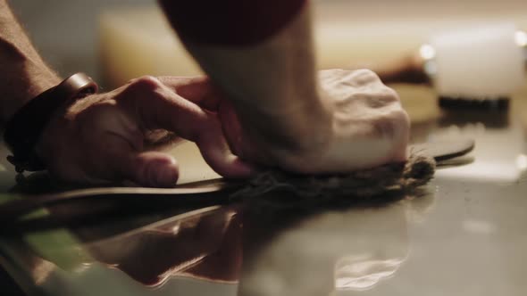 A Man Polishes the Leather Belt Using a Rag