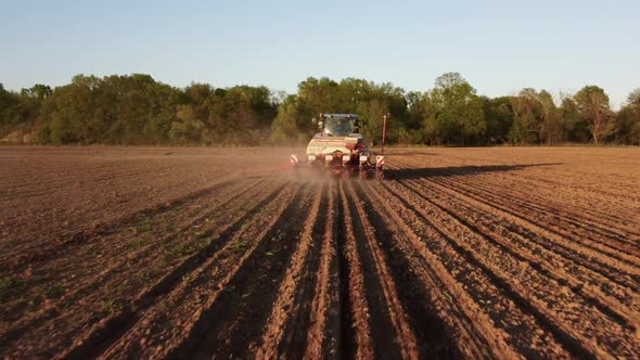 Tractor Working in Field at Sunset