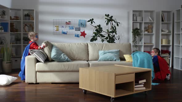 Kids in Superhero Costumes Playing with Pillows at Home alt