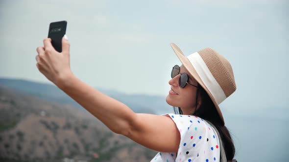 Happy Tourist Woman Posing Taking Selfie on Top of Mountain