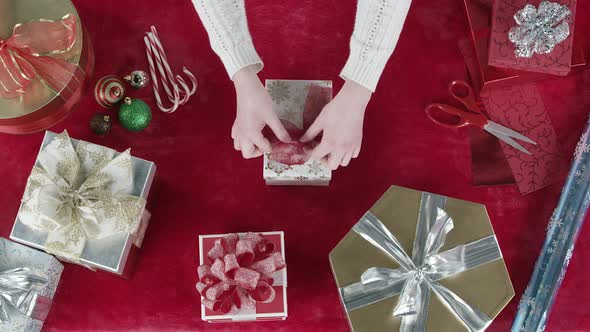 Looking down at gifts on table as person places them on table