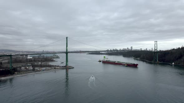 Cargo ship passing under Lions Gate Bridge, Vancouver in Canada. Aerial drone view