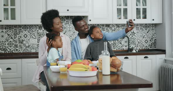 African American Family with Small Kids Doing Selfie on Smartphone in Beautifully Designeted Kitchen