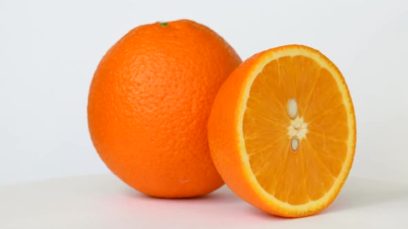 Whole and Half Orange Rotating on White Background