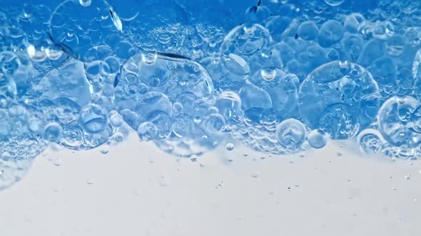 Macro Shot of Various Air Bubbles in Water Rising Up on Light White Background