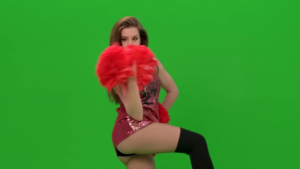 Slim Cheerleader with Long Hair Dances with Red Pompoms