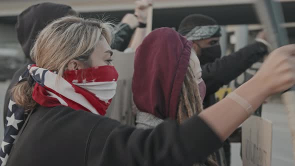 Young Activists with Signs Protesting before Riot Police