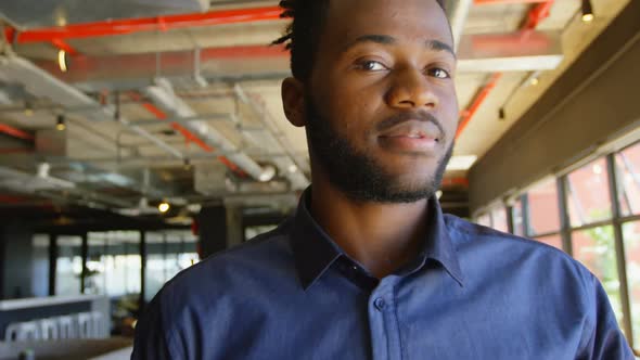 Front view of happy young black businessman looking at camera in a modern office 4k