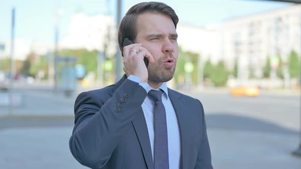 Angry Businessman Talking on Phone Outdoor