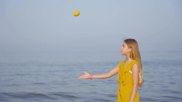 Teen Throws a Lemon in Slow Motion in Front of the Sea