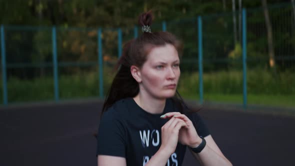 Woman Squatting Down on the Sports Ground Morning Exercises