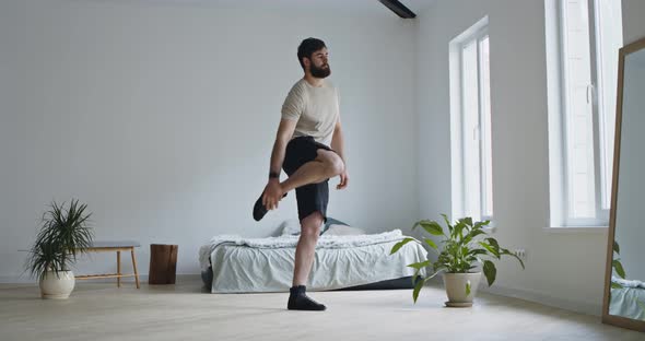 Young Bearded Guy Doing Stretching Exercise for Legs