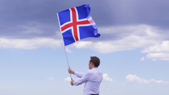 Young man waving Icelandic flag.
