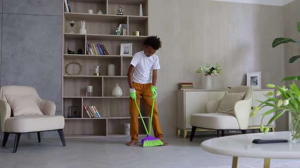 Front View of African American Boy is Cleaning His Room During Quarantine at Home Spbi