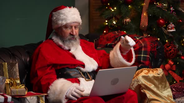 Cute Santa Claus Communicates By Video Call Using Laptop