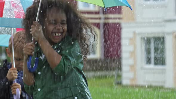 Laughing Preschooler Jumping in Rain