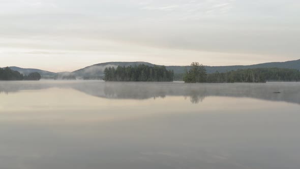 Foggy Glass like reflective water on Prong Pond low angle aerial