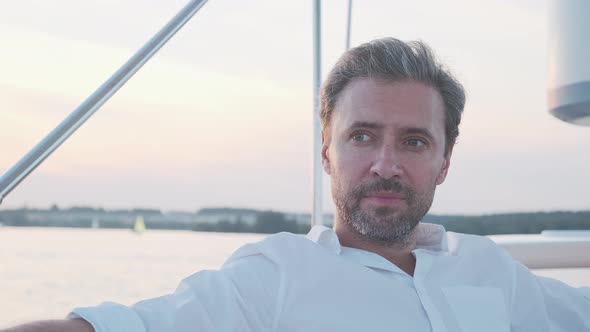 Portrait of Handsome Man on the Yacht. Close Up of Confidence Man on Sailing Boat at Sunset in