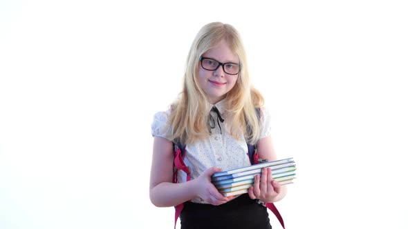 Beautiful Schoolgirl with a School Backpack and Wearing Glasses Posing in the Studio on a White