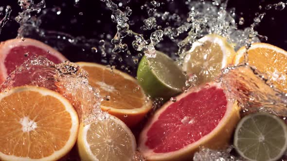 Slow Motion Shot of Citrus Fruits and Water Splashing Through Lemon Lime Grapefruit Slices