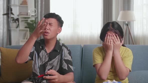 Asian Children With Joystick Game Playing Video Games And Disappointed